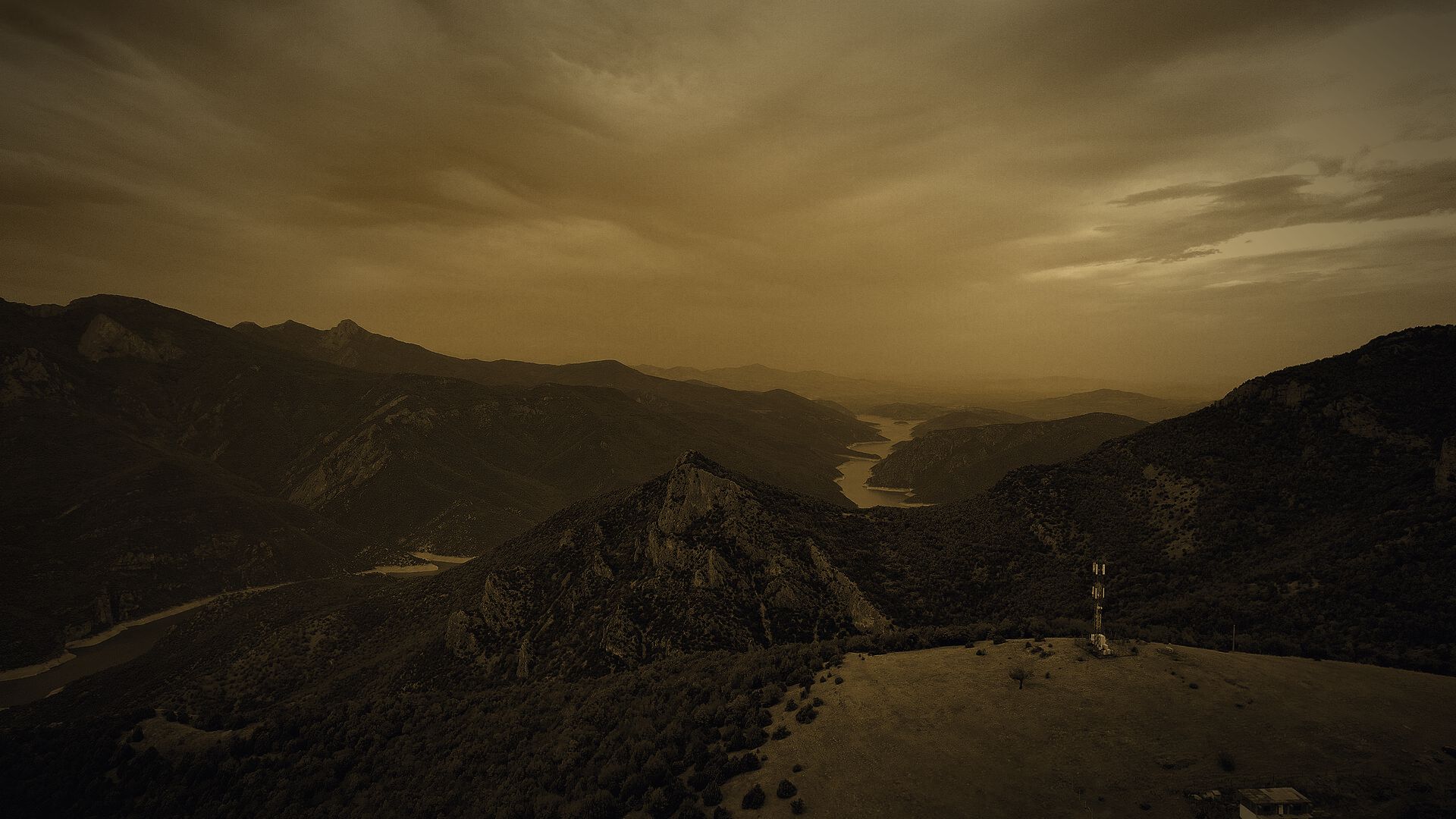 Tikveš Lake winding through the gorge below Kavadarci under a storm sky